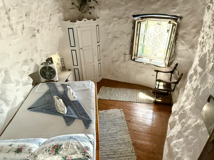 Dressing table and mirror in a stone-walled bedroom at Eco House Patmos