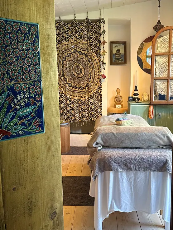 Indoor massage table with patterned wall hangings at Eco House Patmos