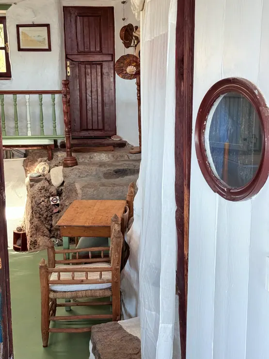 Kitchen viewed through a white doorway with an oval mirror at Eco House Patmos