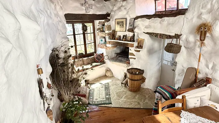 Living and dining space with white walls and salvaged timber details at Eco House Patmos