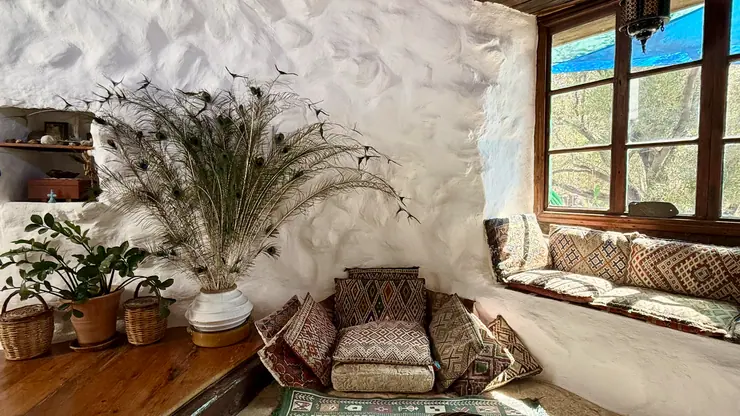 Armchair and built-in seating beside a window in the living room at Eco House Patmos