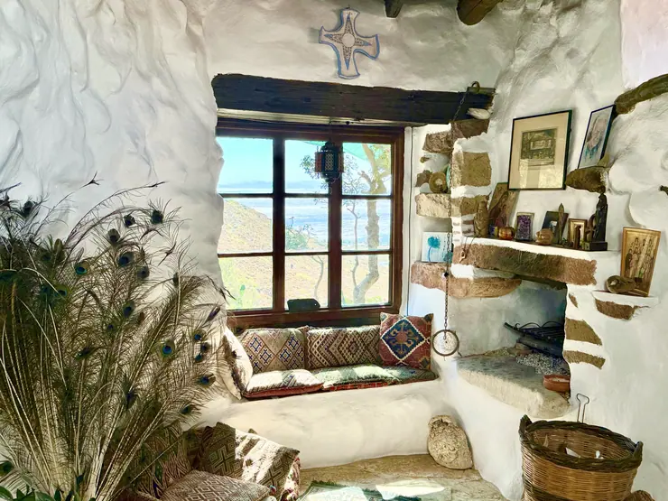 Sitting area beside a large window with green wooden shutters at Eco House Patmos
