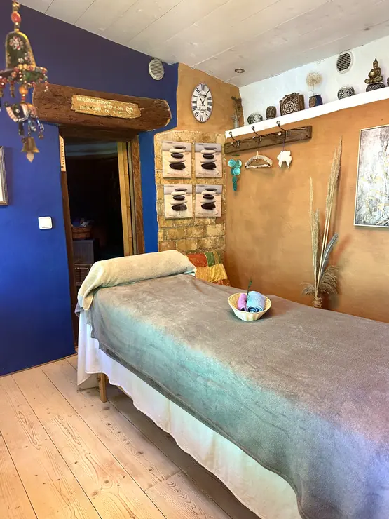 Massage table beneath a timber ceiling beside blue and wood walls at Eco House Patmos