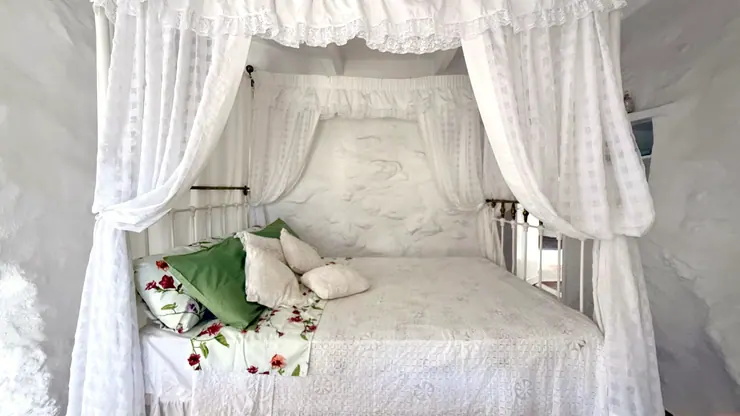 White canopy curtains and linen on the queen bed at Eco House Patmos