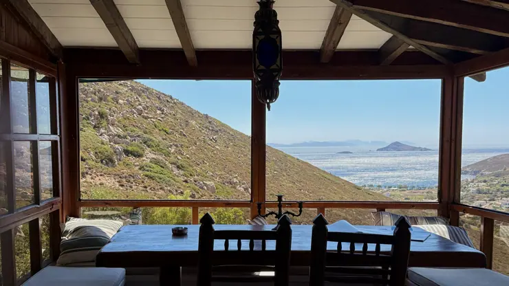 View of the sea and hills from the glazed main house room at Eco House Patmos