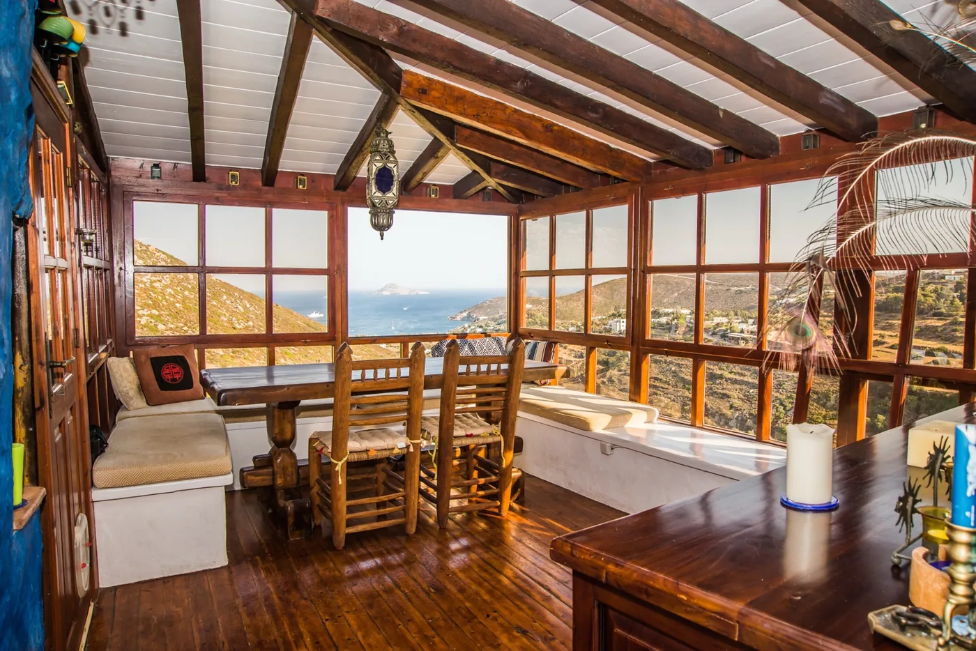 Wooden dining room with windows looking out over Patmos